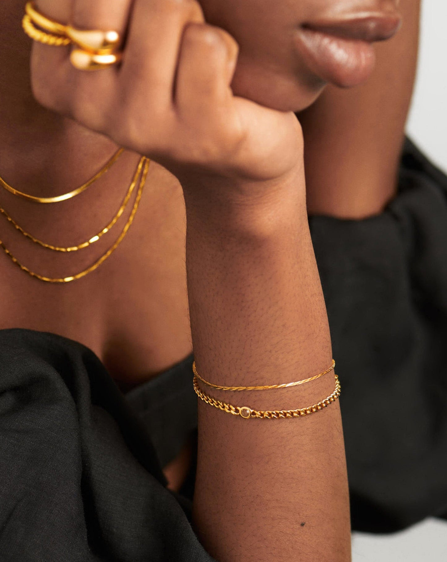 Gold birthstone bracelet stacked on wrist