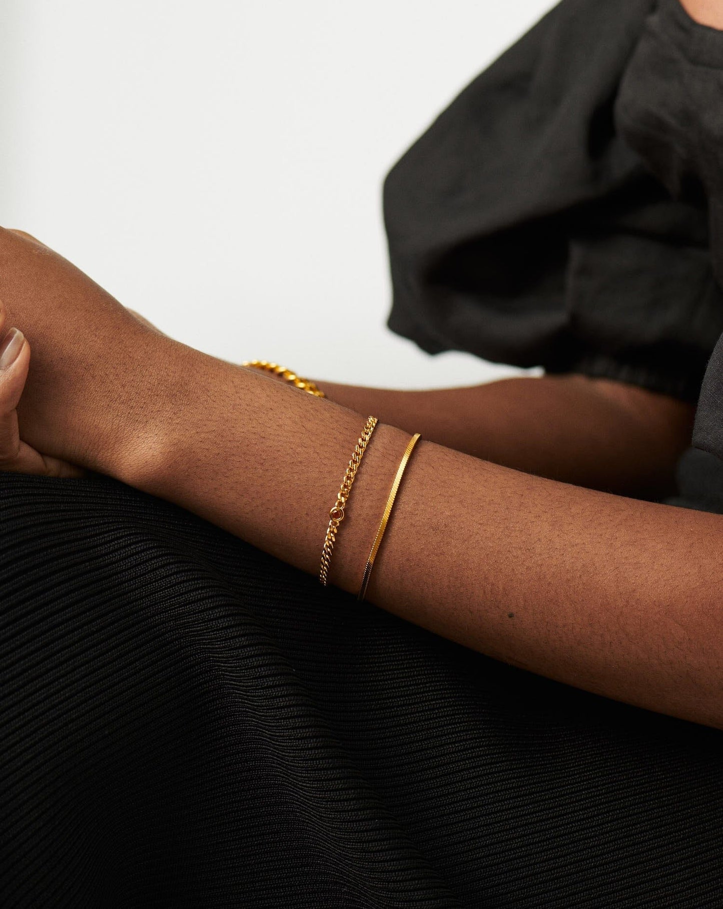 Gold birthstone bracelet stacked on wrist