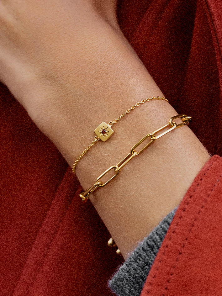 Gold Birthstone bracelet and chain bracelet on wrist