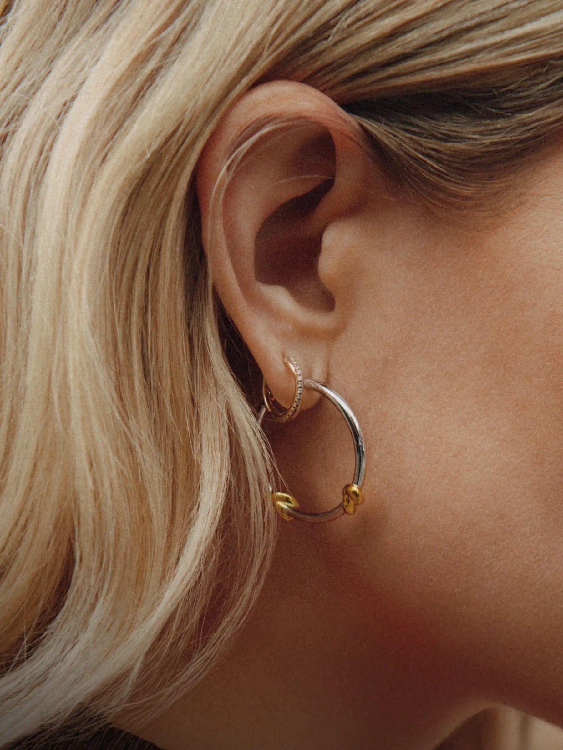 gold earrings on green tile flooring