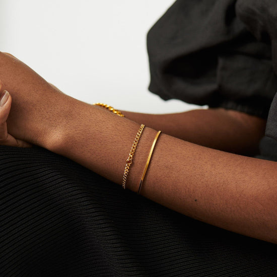 Gold birthstone bracelet stacked on wrist